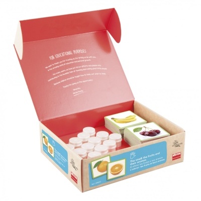 Caixa aberta com frascos e cartões de frutas para fins educativos