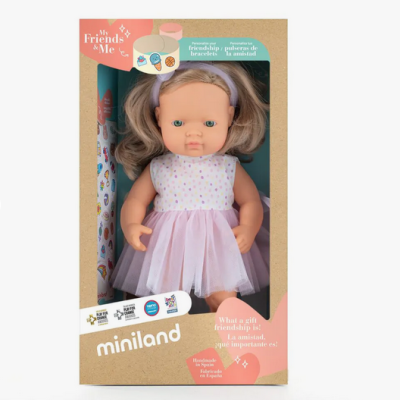 Boneca em caixa com vestido branco e saia rosa com textos em inglês e espanhol