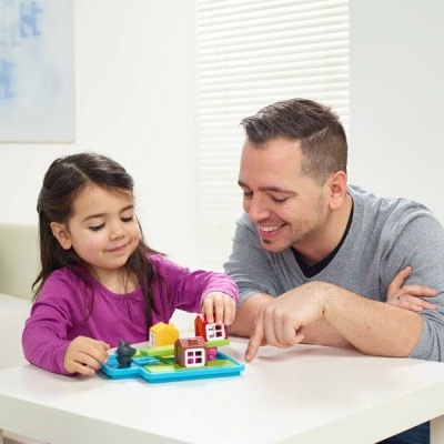 Brinquedo de jogo de tabuleiro infantil com casas coloridas numa mesa branca