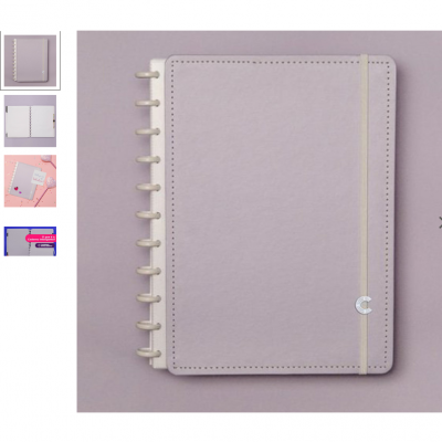 Caderno lilás com capa rígida, elástico creme e argolas visíveis