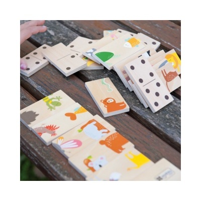 Peças de dominó de madeira com animais coloridos e pontos pretos numa mesa de madeira