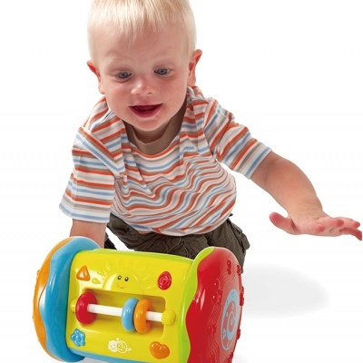 Menino pequeno loiro com brinquedo colorido de plástico cylindrical