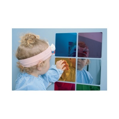 Criança toca em espelhos coloridos quadrados na parede