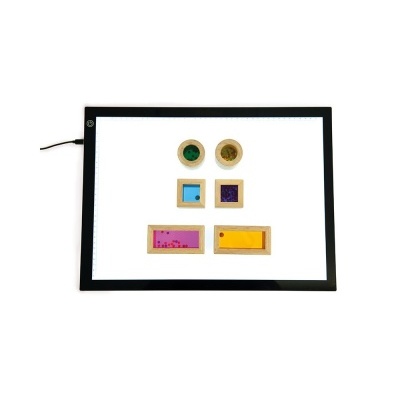 Mesa de luz iluminada com seis objetos coloridos organizados sobre ela