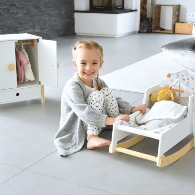 Cama de madeira para bonecas com tenda colorida, menina numa sala moderna