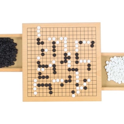 Tabuleiro de jogo Go em madeira com pedras pretas e brancas