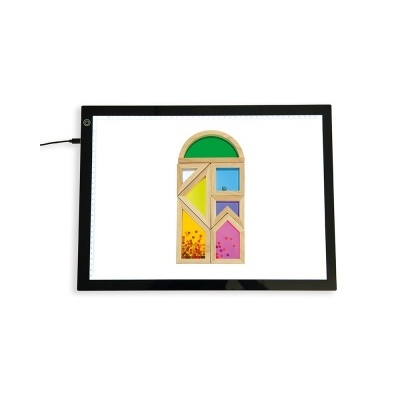 Mesa luminosa preta com brinquedo de madeira colorido em forma de janela