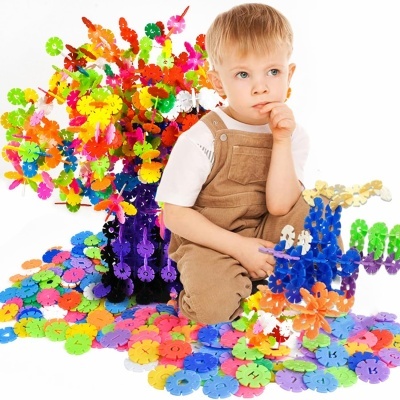 Criança a brincar com peças de construção coloridas em forma de discos