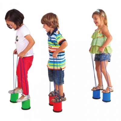 Três crianças a brincar com brinquedos de equilíbrio coloridos em fundo branco