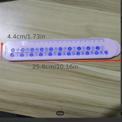 Régua rosa de plástico com números azuis sobre superfície de madeira clara