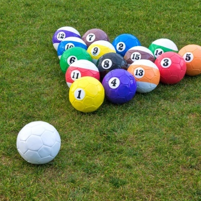 Bolas de futebol coloridas numeradas em relva verde