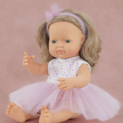 Boneca com vestido cor-de-rosa sentada em fundo rosa