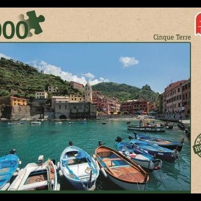 Caixa de puzzle com imagem de barcos na água em frente a casas coloridas próximas a colina