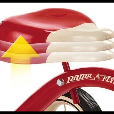 Assento vermelho e branco ajustável de bicicleta infantil com texto 'Radio Flyer' no quadro vermelho.