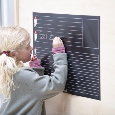 Criança escrevendo em quadro negro magnético com linhas e desenhos de faróis