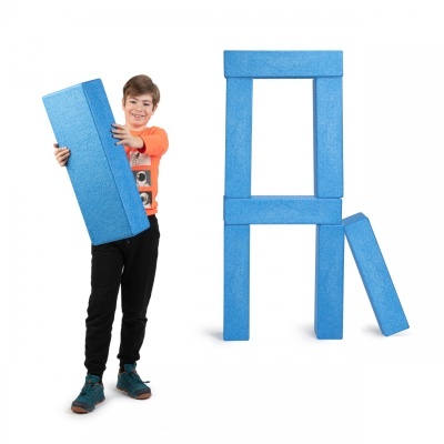 Menino com peça azul de espuma e estrutura azul ao lado em fundo branco