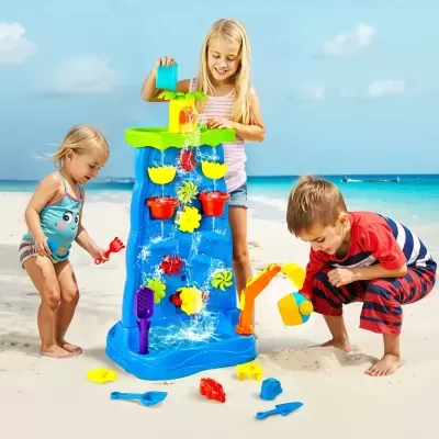 Crianças na praia brincando com brinquedo de água colorido e brinquedos para areia.