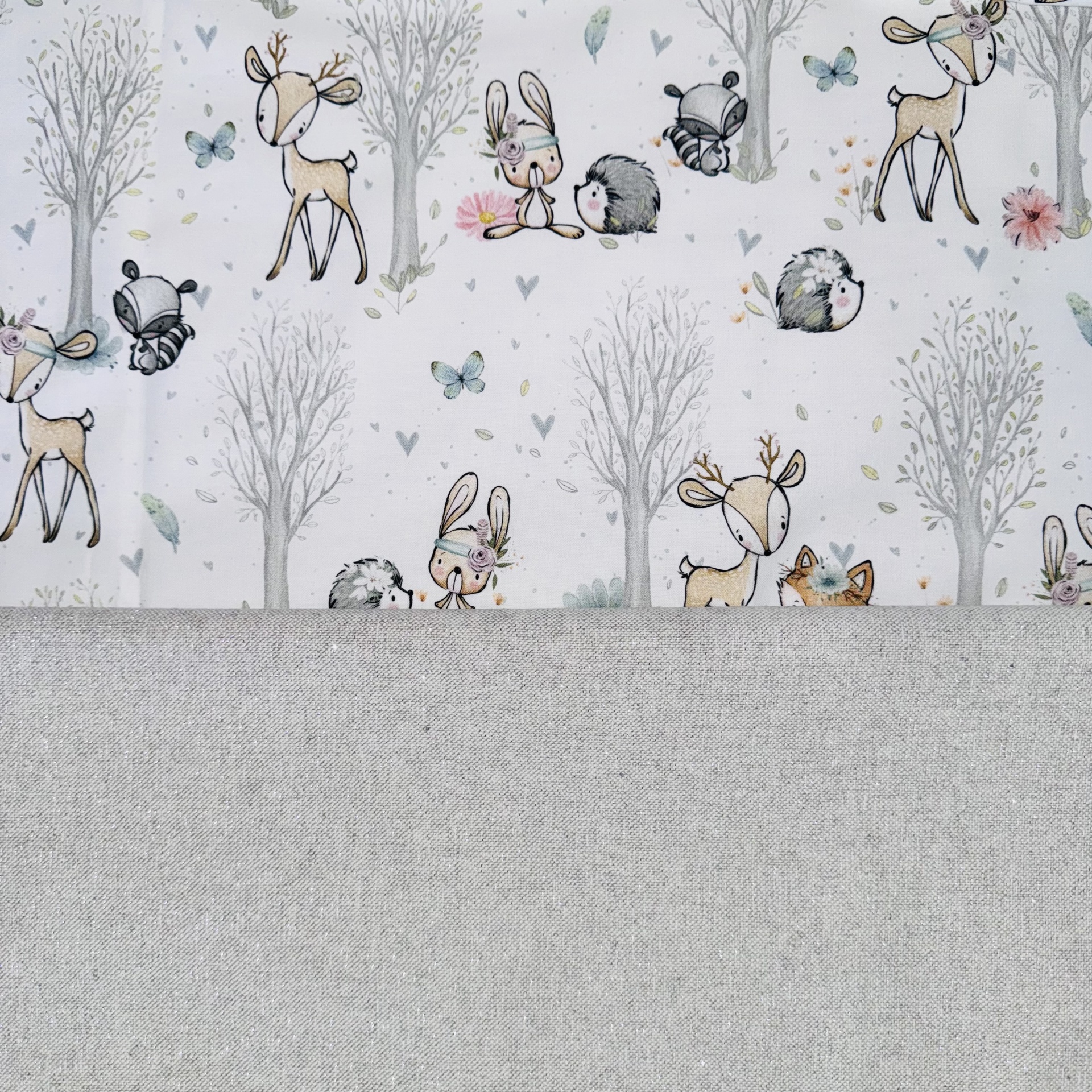 Tecido infantil com animais e árvores em fundo branco e tecido cinza liso