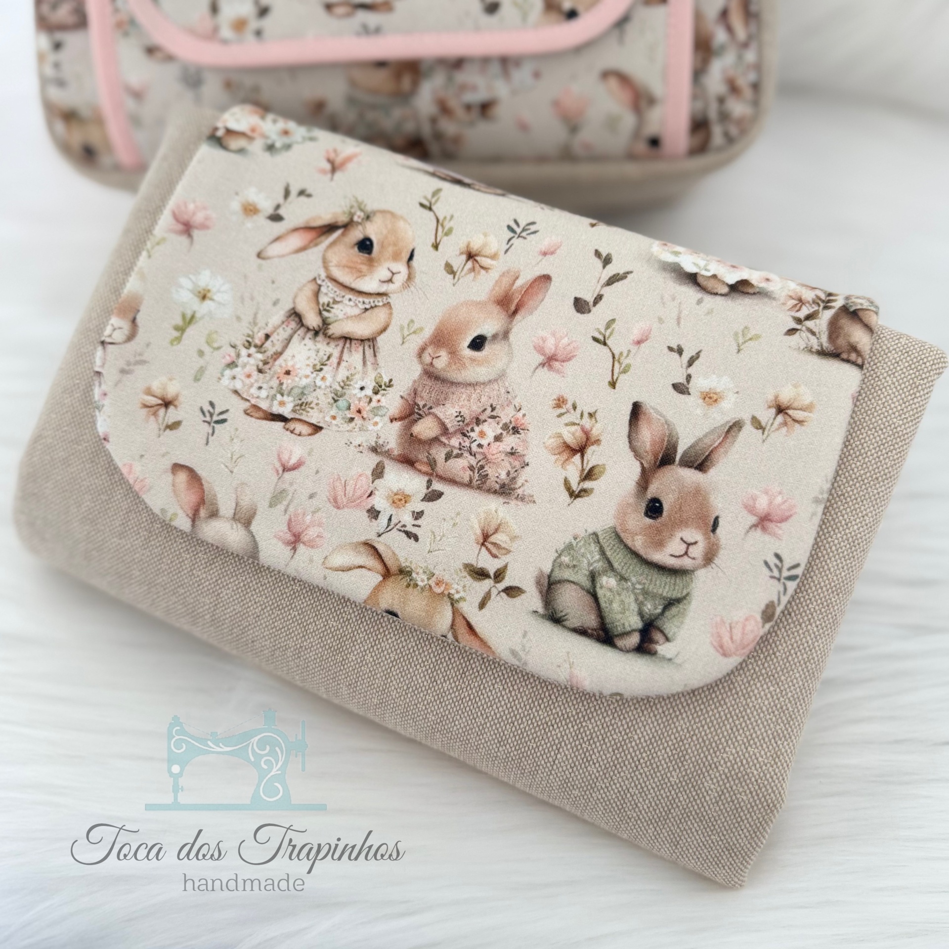 Carteira de tecido bege com estampa de coelhos vestidos e flores