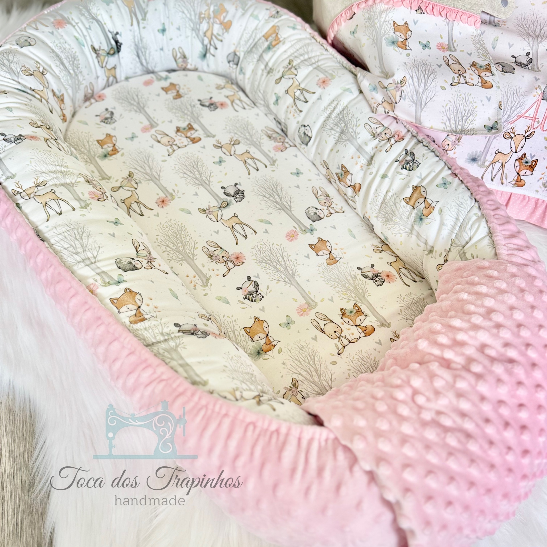 Ninho de bebé rosa artesanal com padrão de animais e textura almofadada