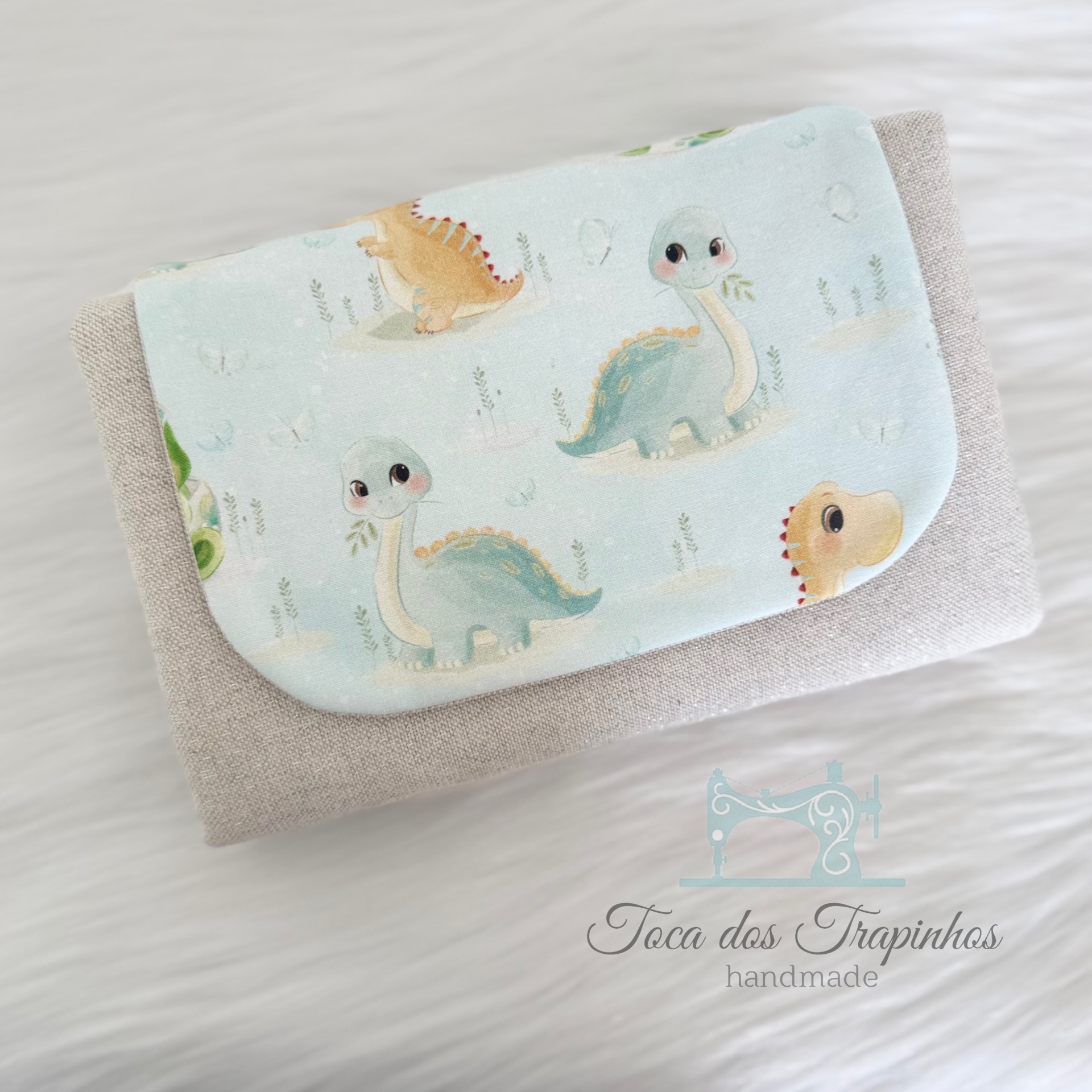 Carteira bege com aba azul claro estampada com dinossauros infantis
