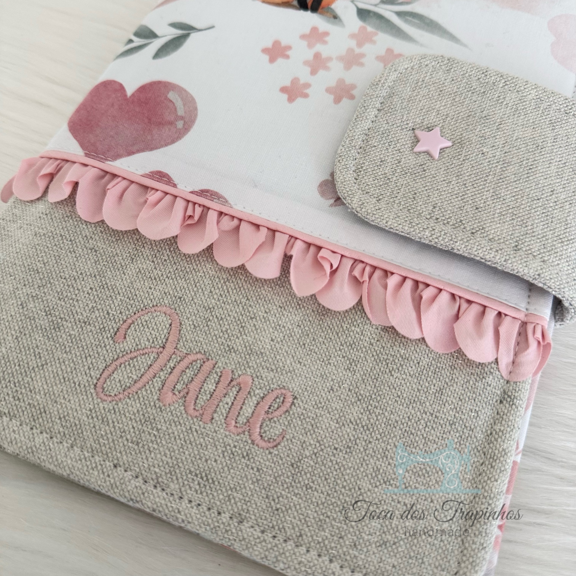 Bolsa artesanal em tecido cinza e branco com estampas florais cor de rosa e botão estrela rosa