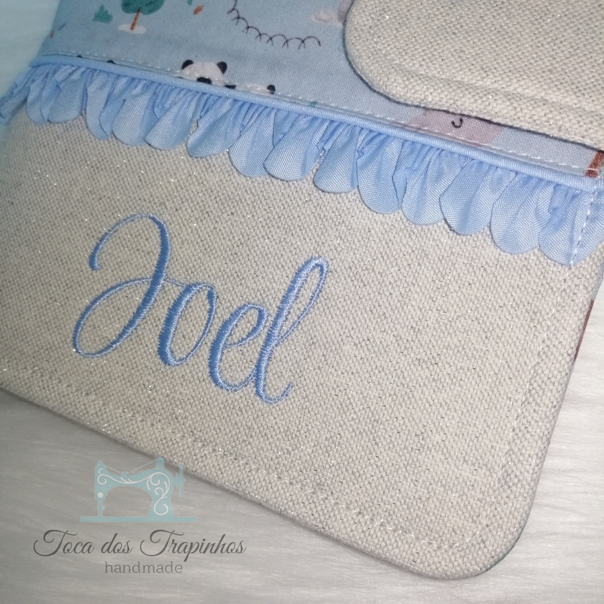 Bolsa de tecido bege com bordado azul e decoração azul