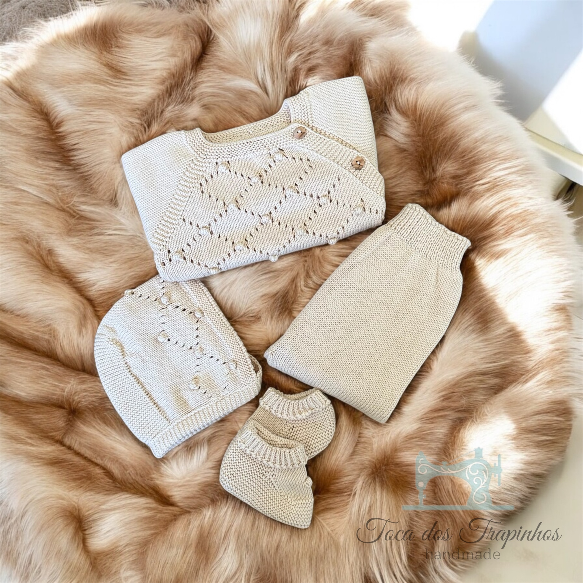 Conjunto de roupa de bebé em malha creme com padrão em losangos