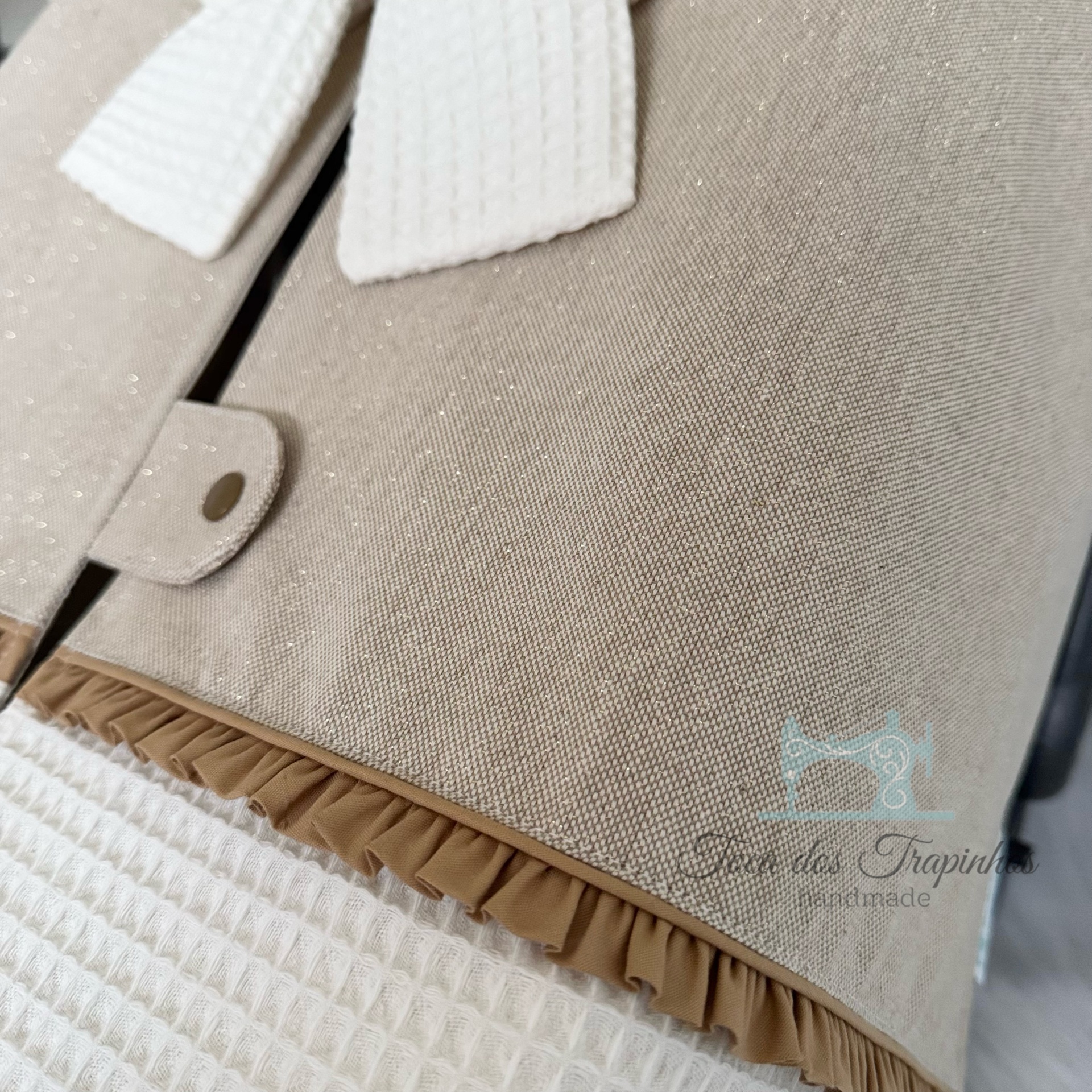 Bolsa em tecido bege com detalhes em branco e castanho