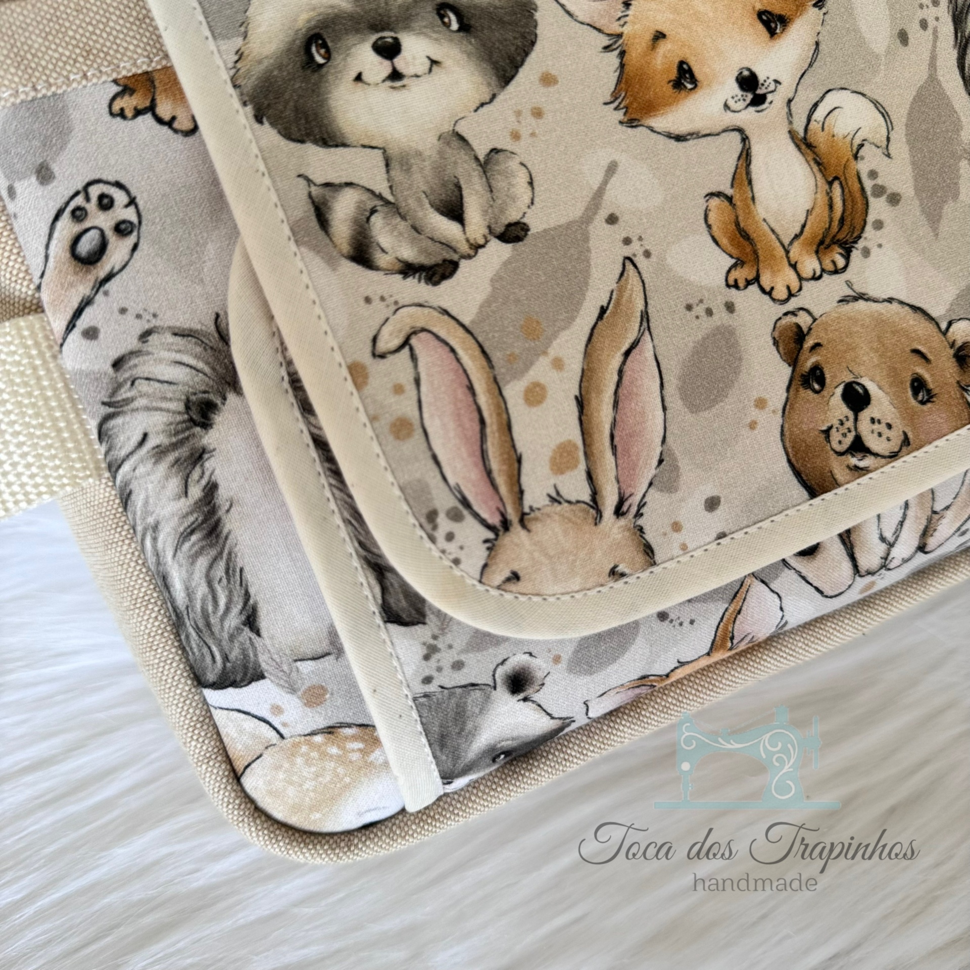 Bolsa ou capa de tecido com desenho de animais e etiqueta artesanal