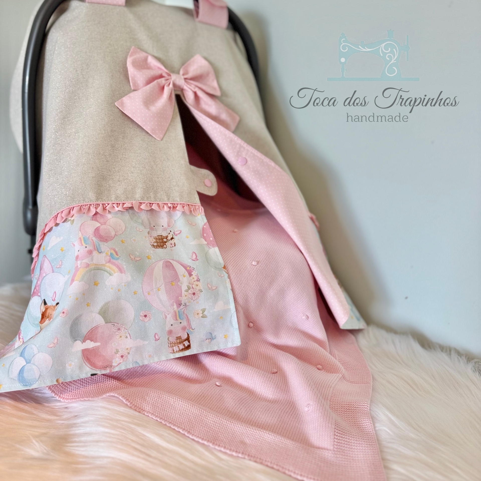 Capa para ovo de carro bege com laço rosa e tecido decorativo colorido, sobre pelo sintético branco