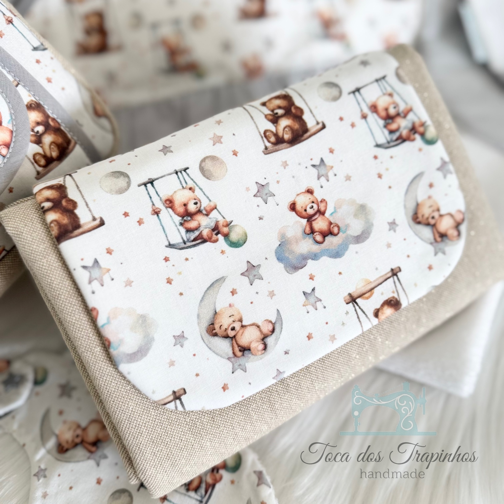 Carteira bege com padrão de ursinhos em balanço e na lua sobre fundo branco