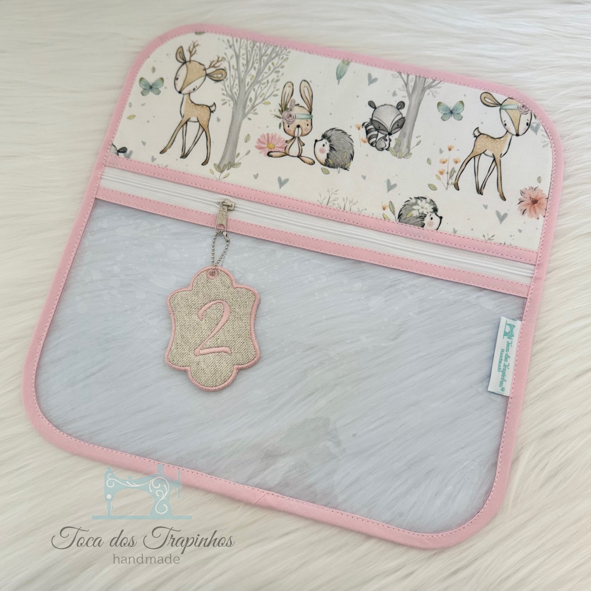 Estojo rosa com estampado de animais da floresta e parte transparente