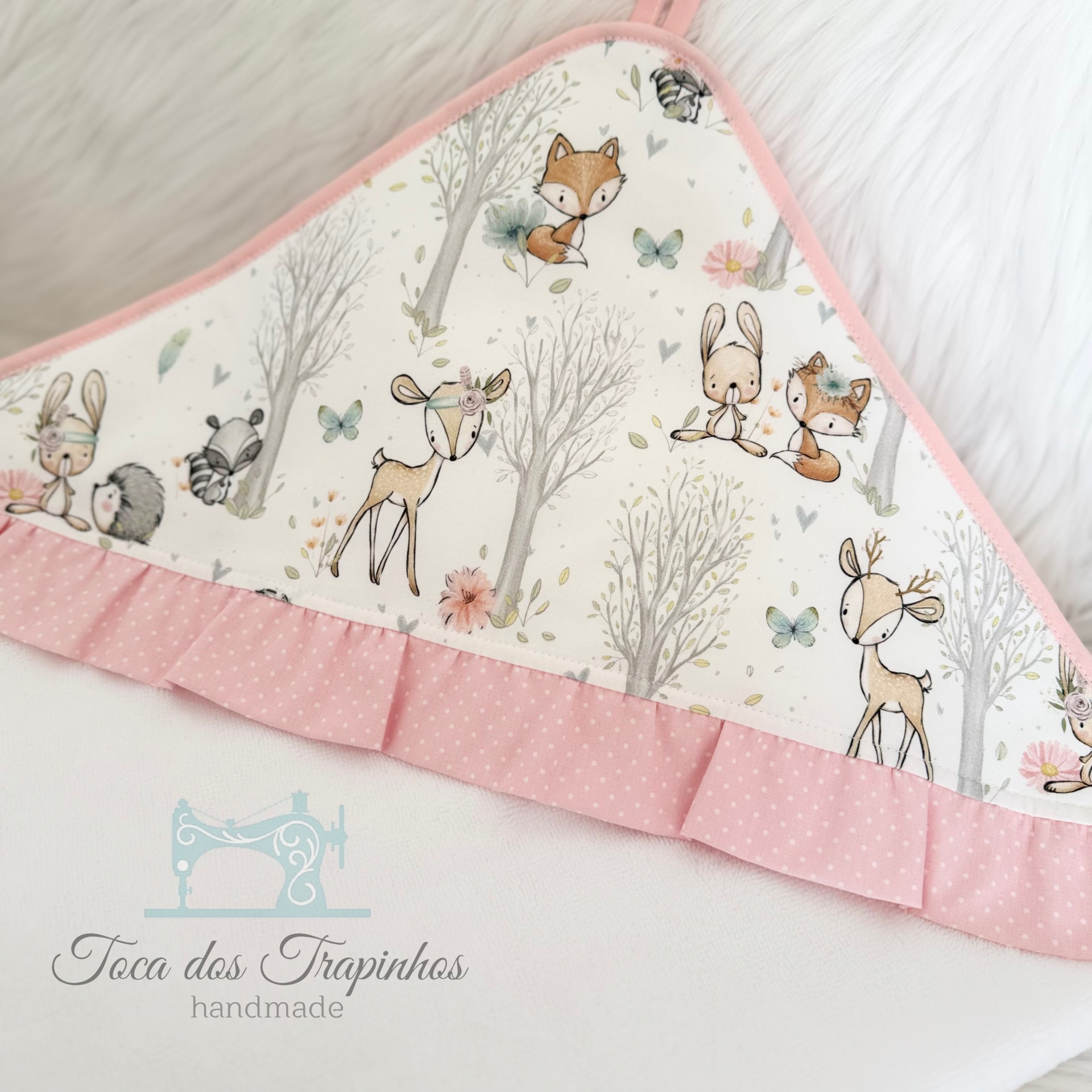 Toalha de banho infantil com padrão de animais da floresta e acabamento rosa claro com bolinhas