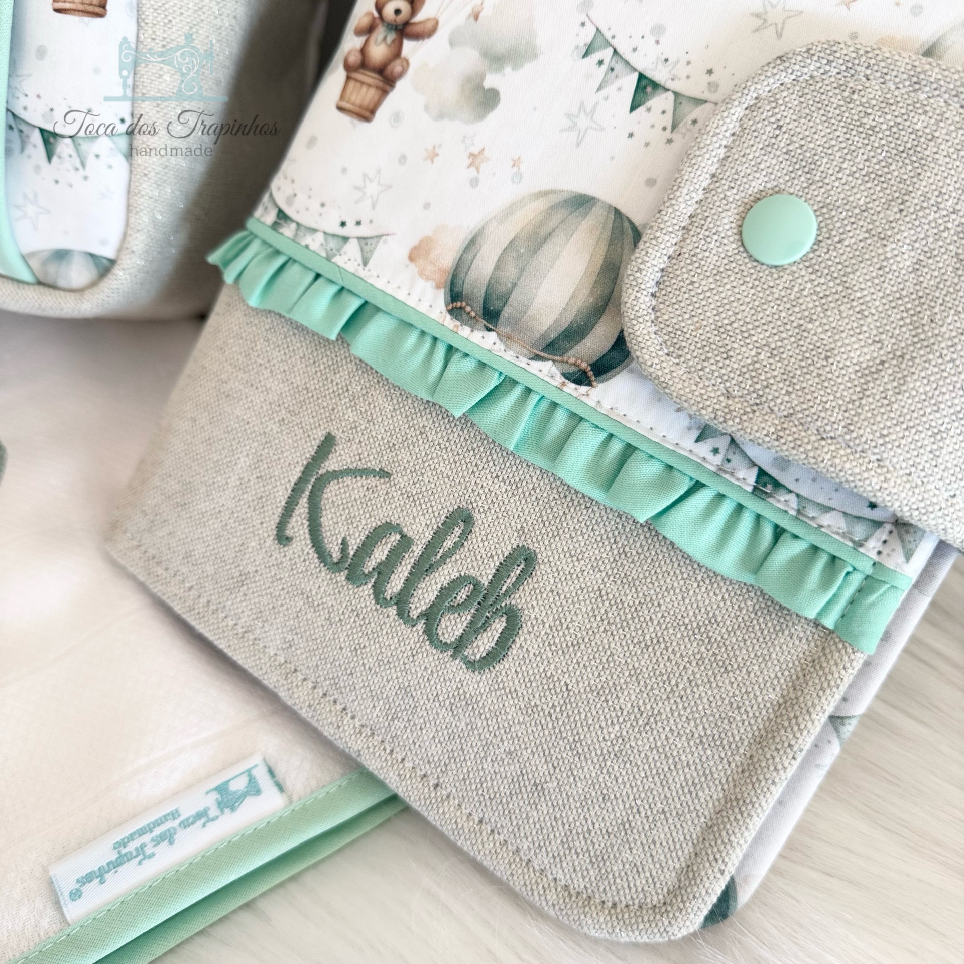 Bolsa de tecido com padrão de balões e ursinhos, com bordado Kaleb e detalhes em verde água