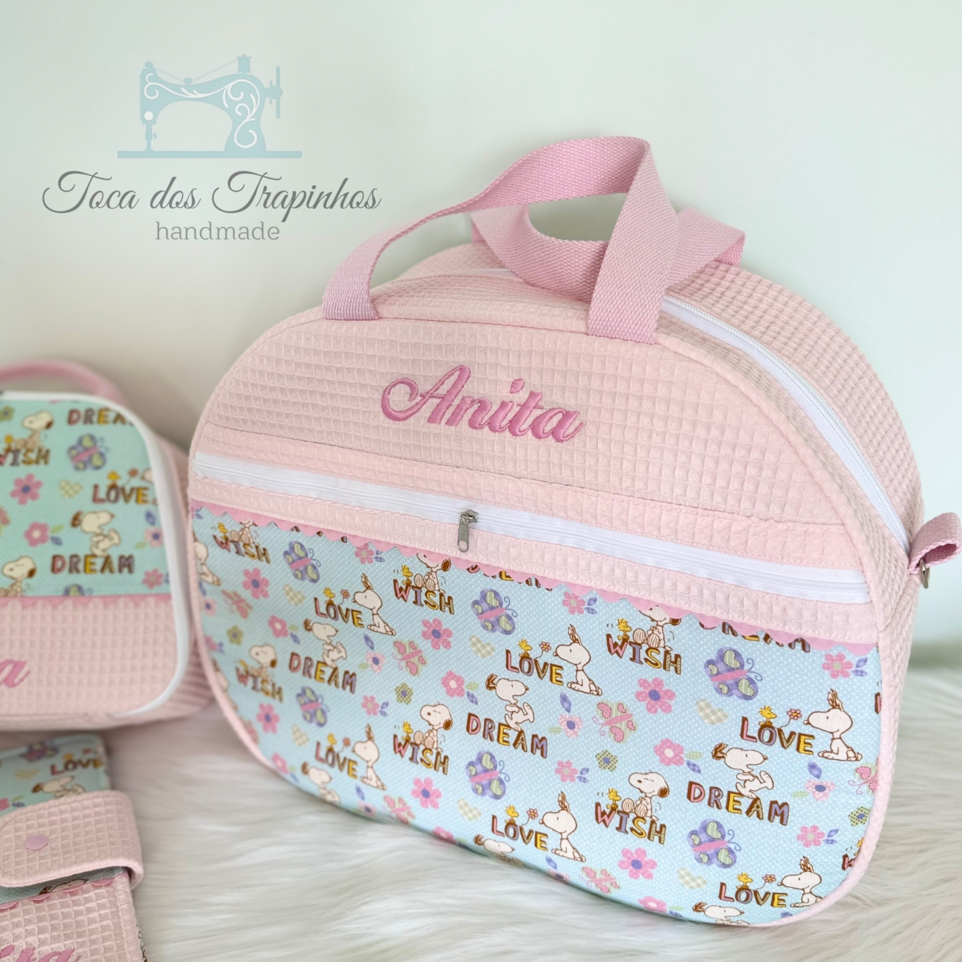 Bolsa de bebé rosa com padrões florais e nome Anita bordado