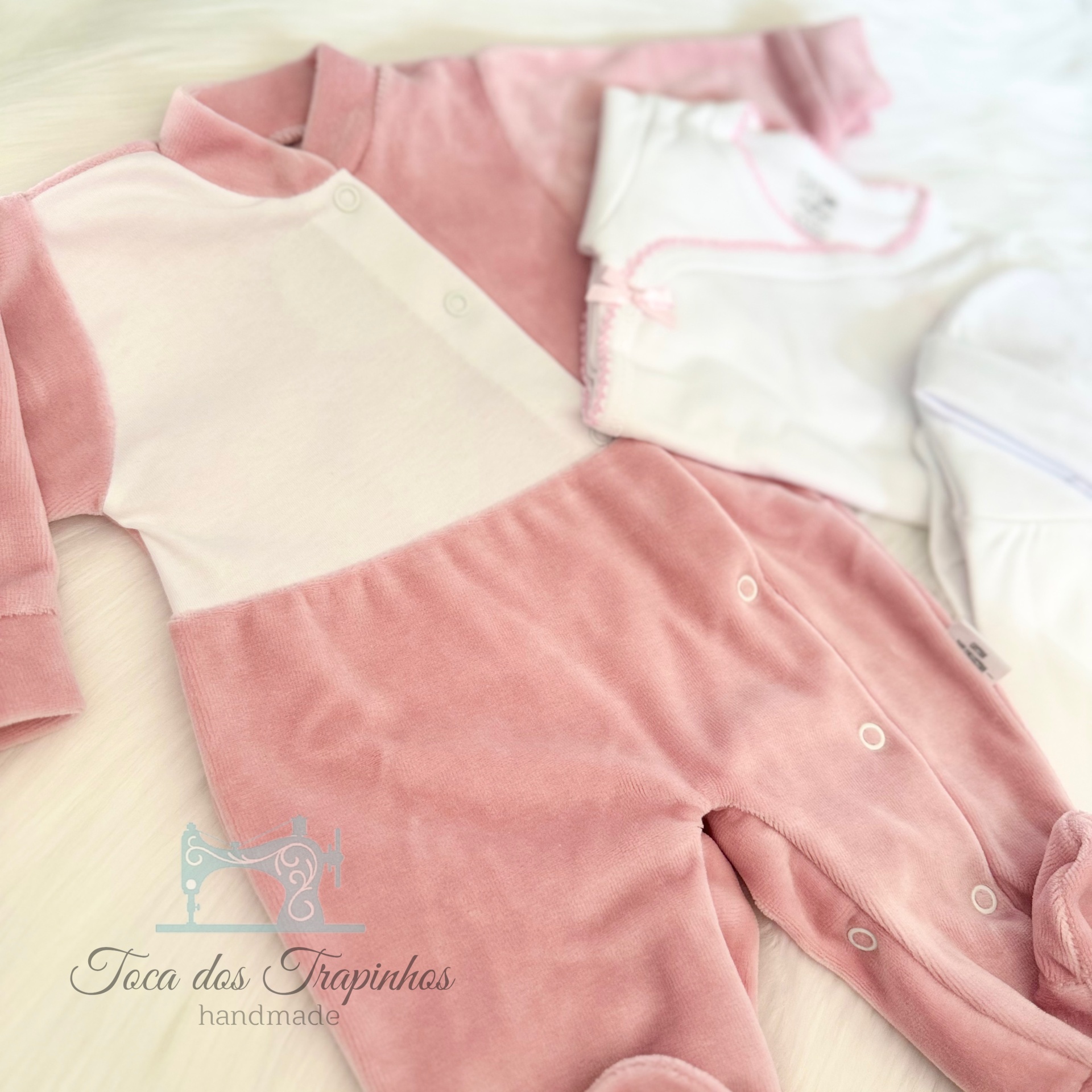 Macacão de bebé rosa e branco felpudo com botão