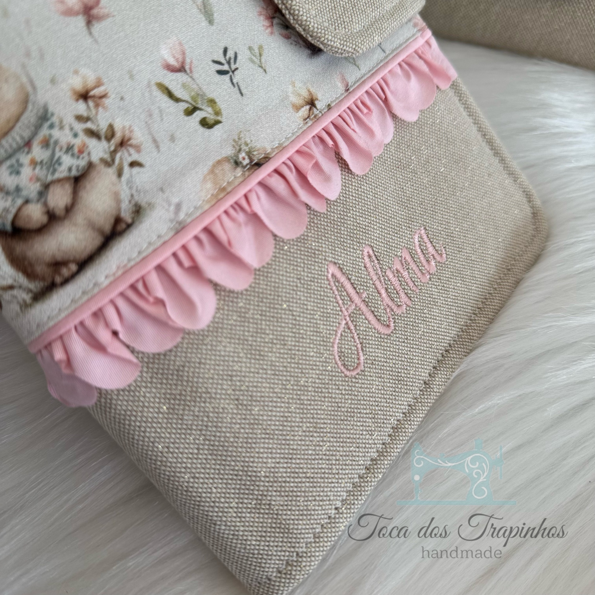 Bolsa bege de tecido com babados rosa e bordado com o nome Alma