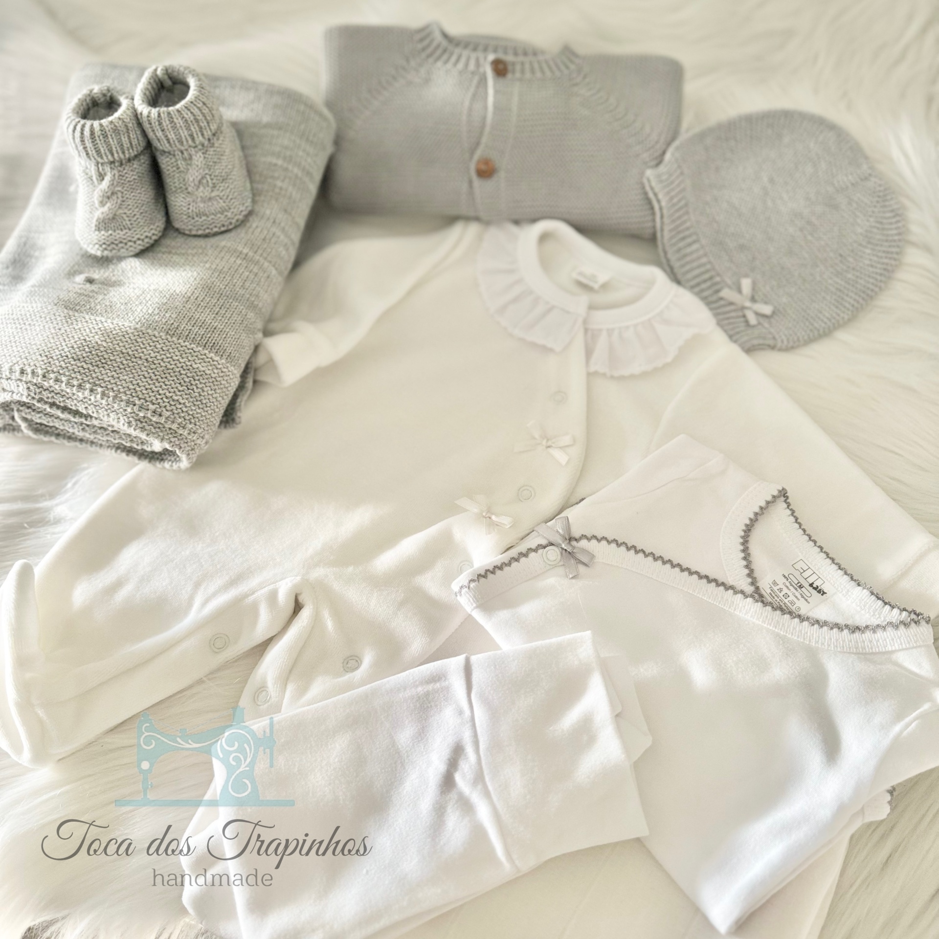 Conjunto de roupa de bebé branco e cinza com peças de malha e algodão