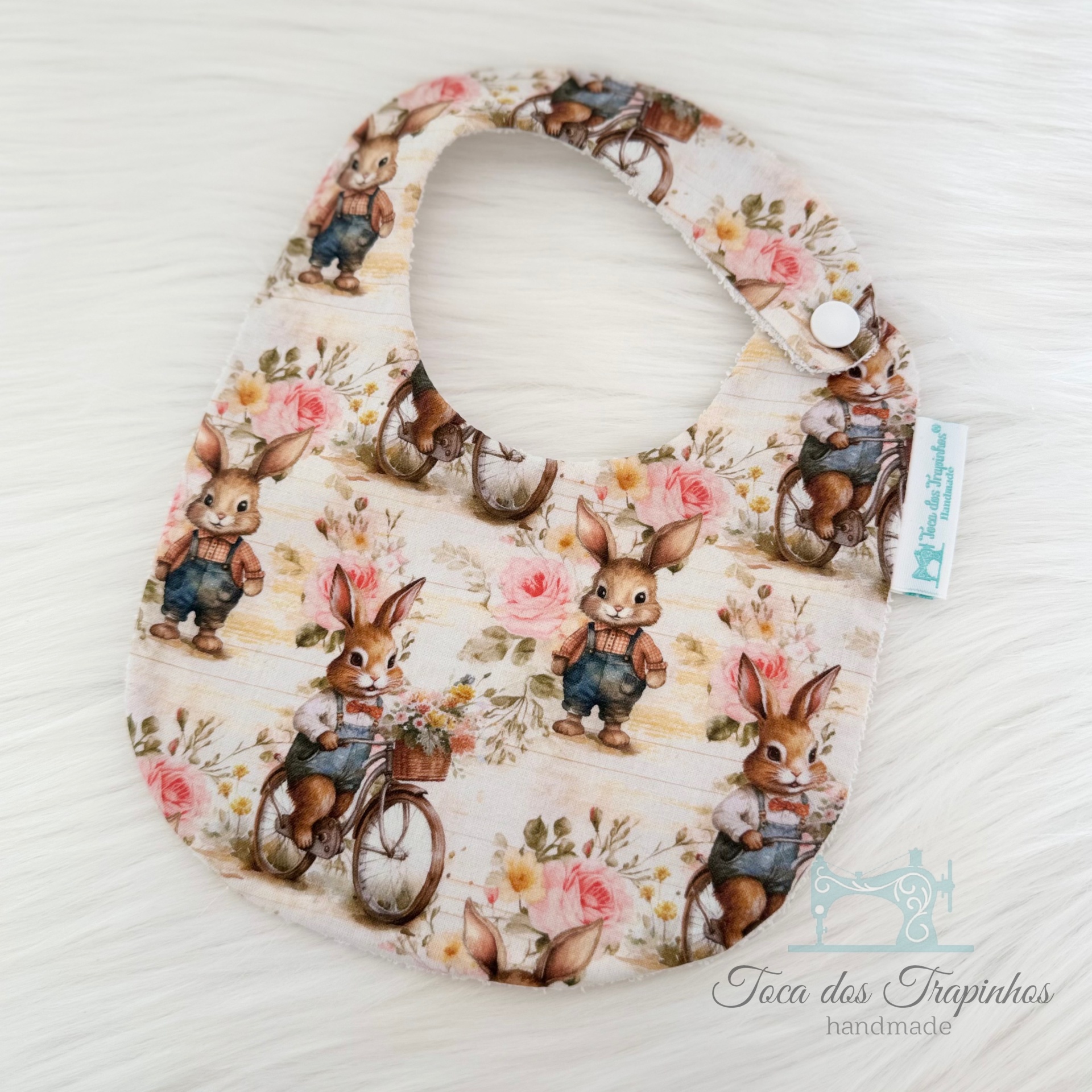 Babete tecido com padrão de coelhos e flores com fecho de pressão
