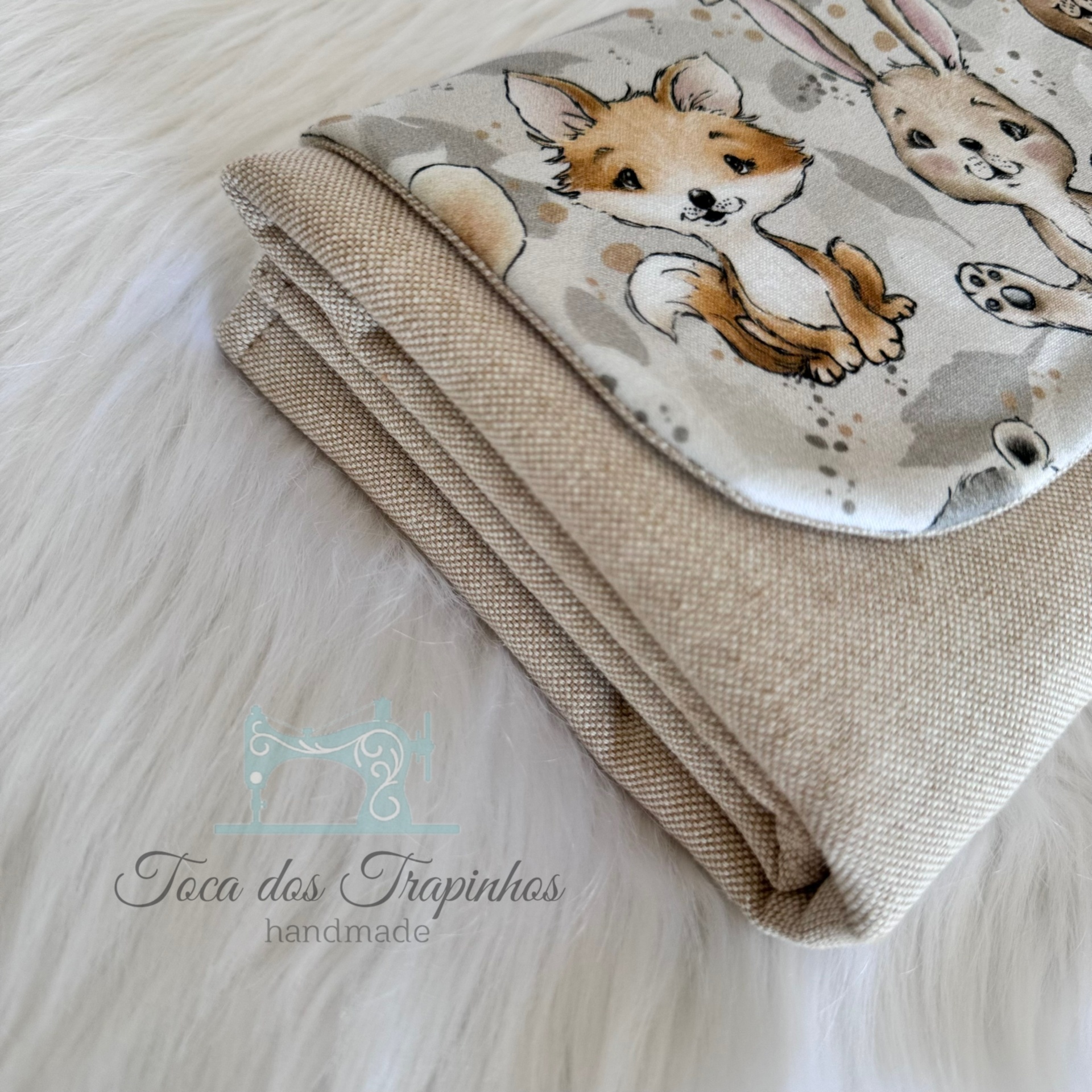 Toalha ou manta bege claro com decoração de animais em patch branco