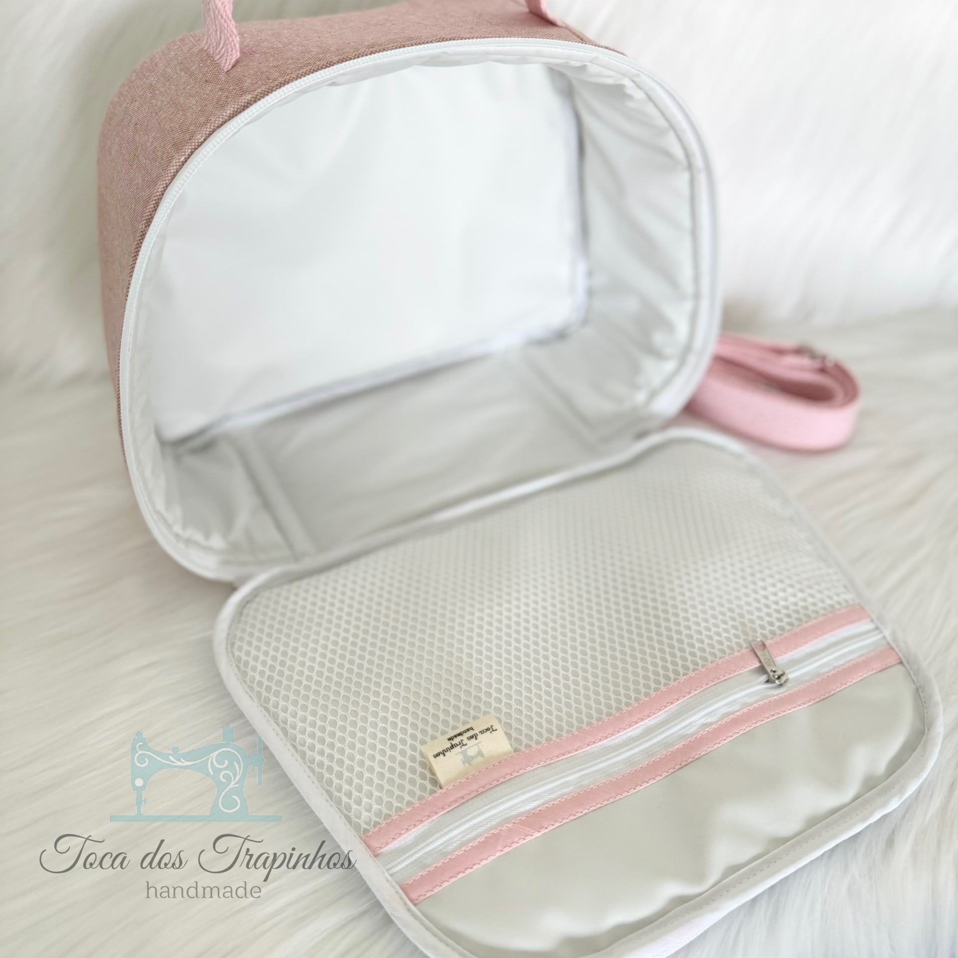 Mala rosa pequena aberta com interior cinzento e bolso de rede