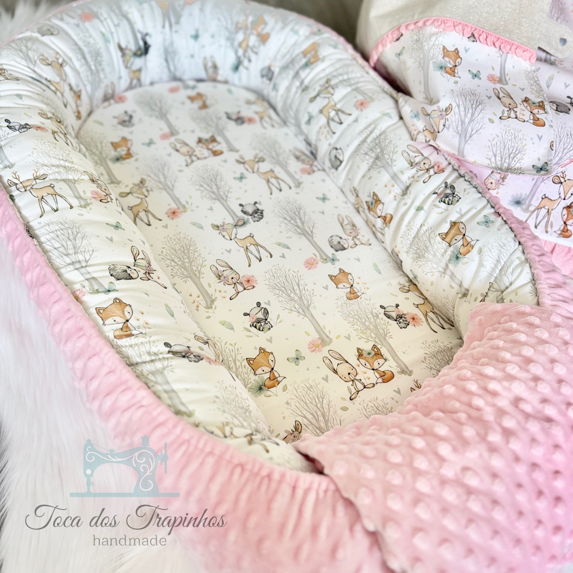 Cama de bebé rosa com estampado de animais em tecido macio