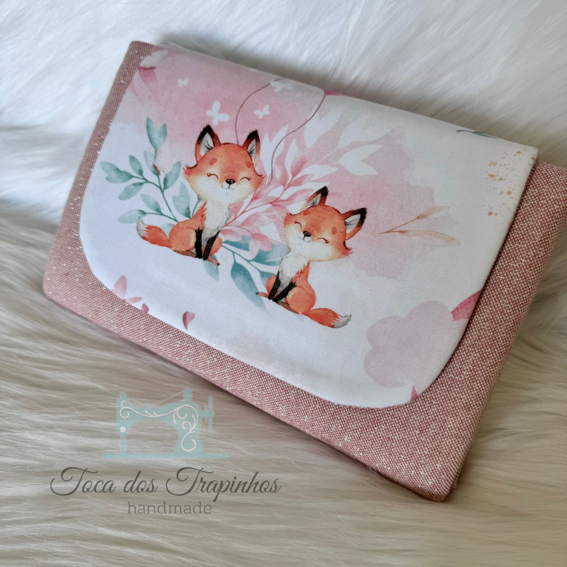 Carteira rosa com flap branco decorado com ilustração de duas raposas e folhas
