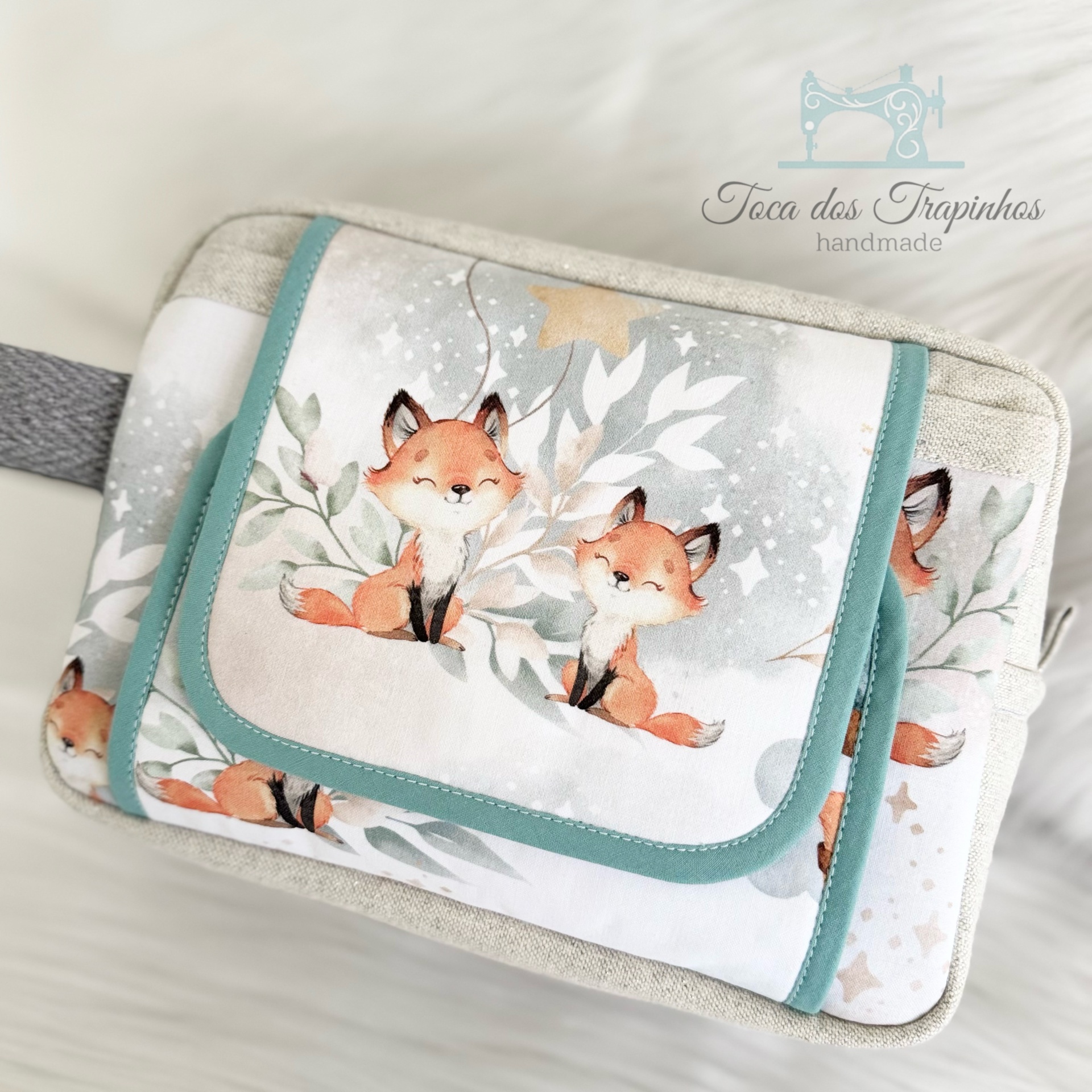 Bolsa de tecido com estampa de raposas e bordas verde água