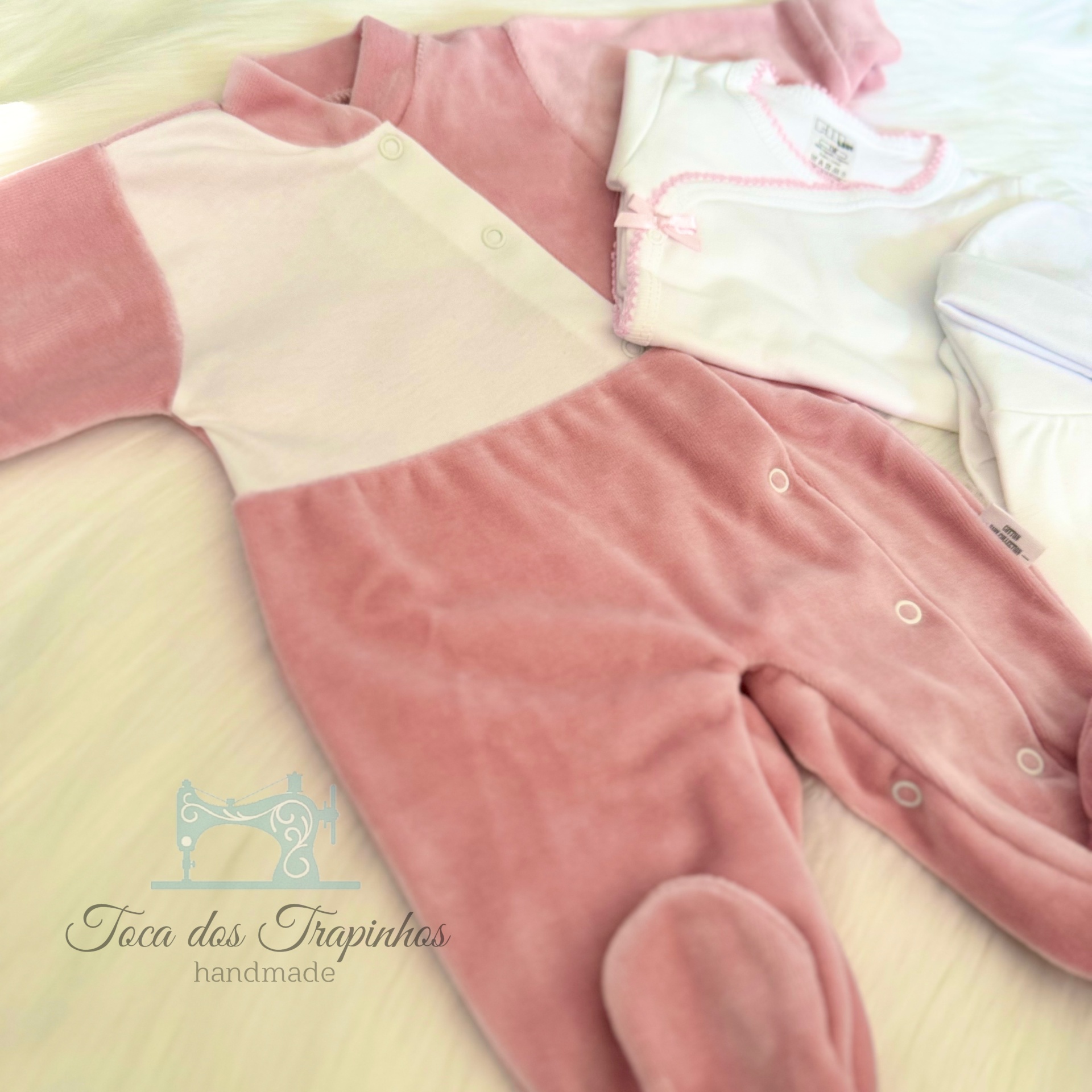 Conjunto de roupa de bebé rosa e branco com gorro, tecido macio, em fundo claro