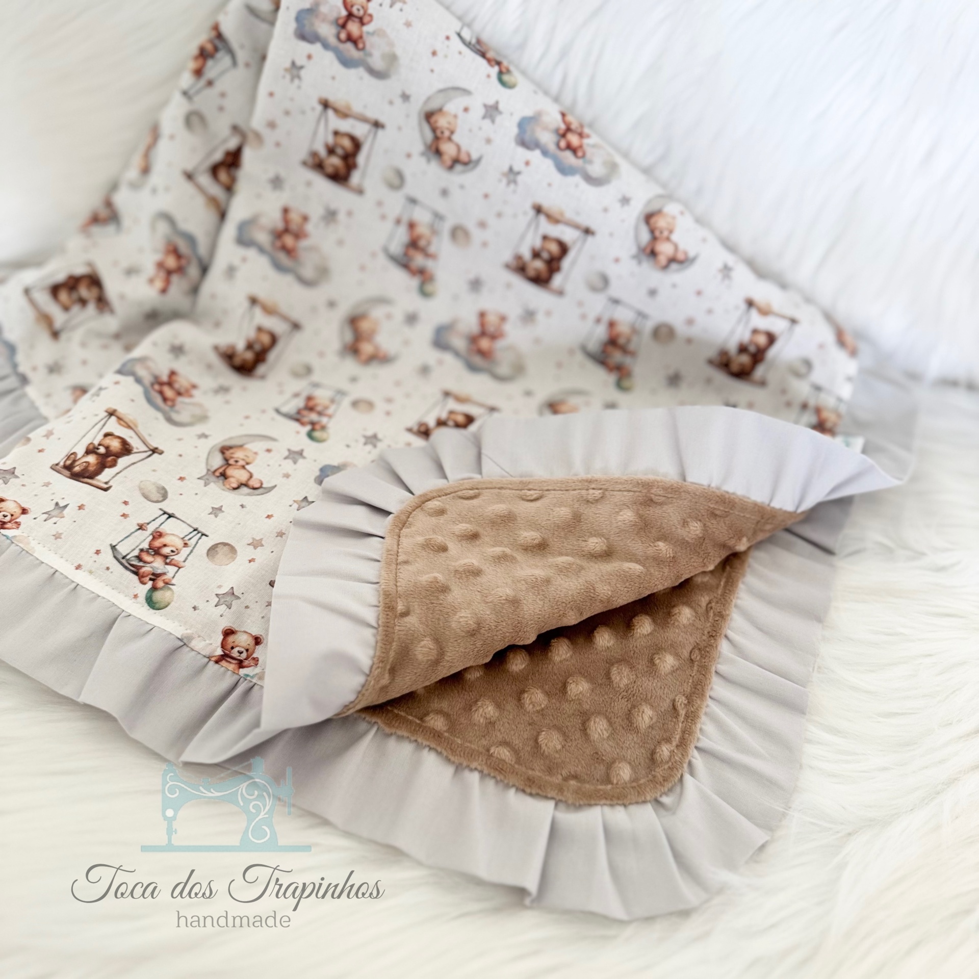 Manta para bebé com padrão de ursinhos e tecido macio castanho.