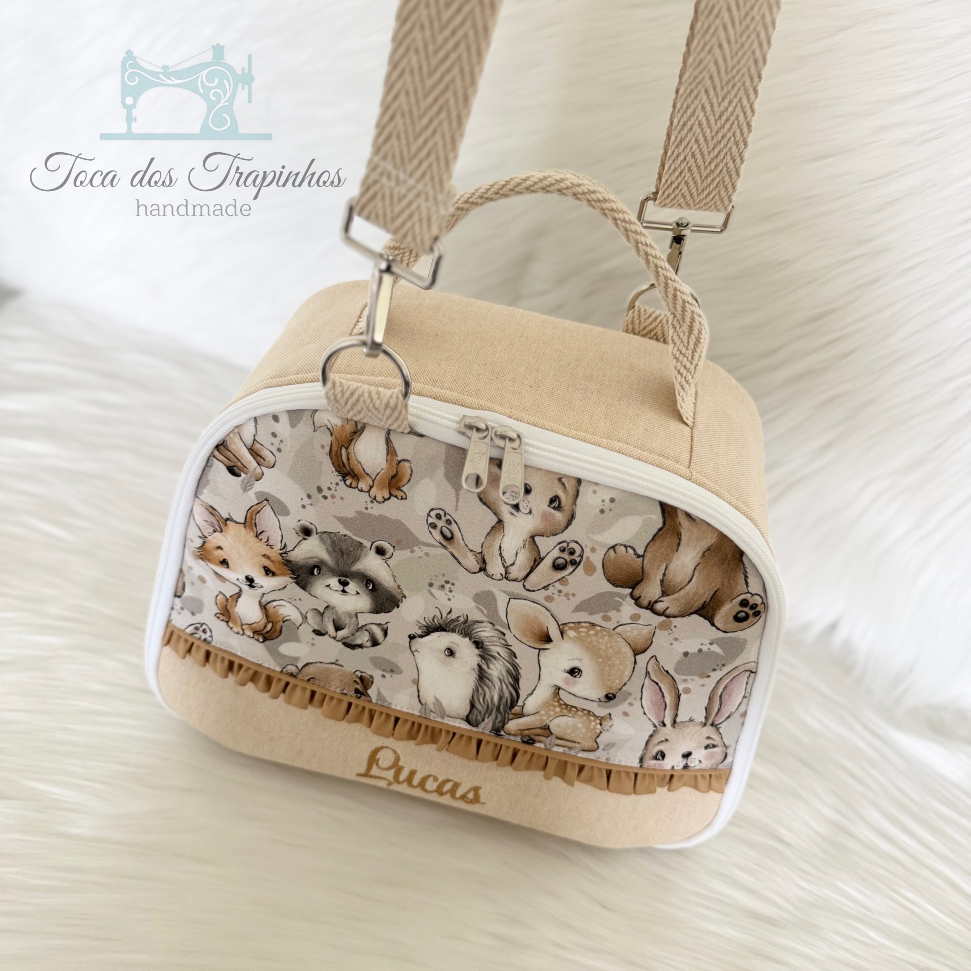 Mala infantil bege com estampado de animais e o nome Lucas bordado