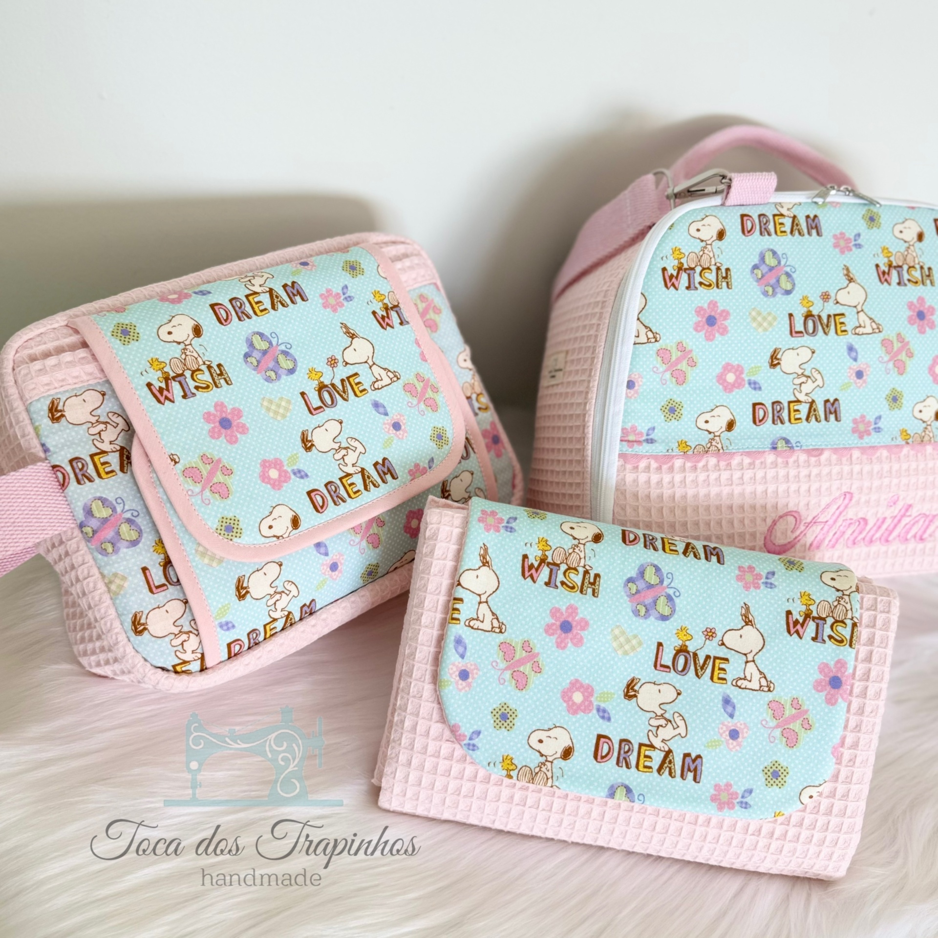 Três bolsas infantis com padrão Azul claro, flores, personagens e texto