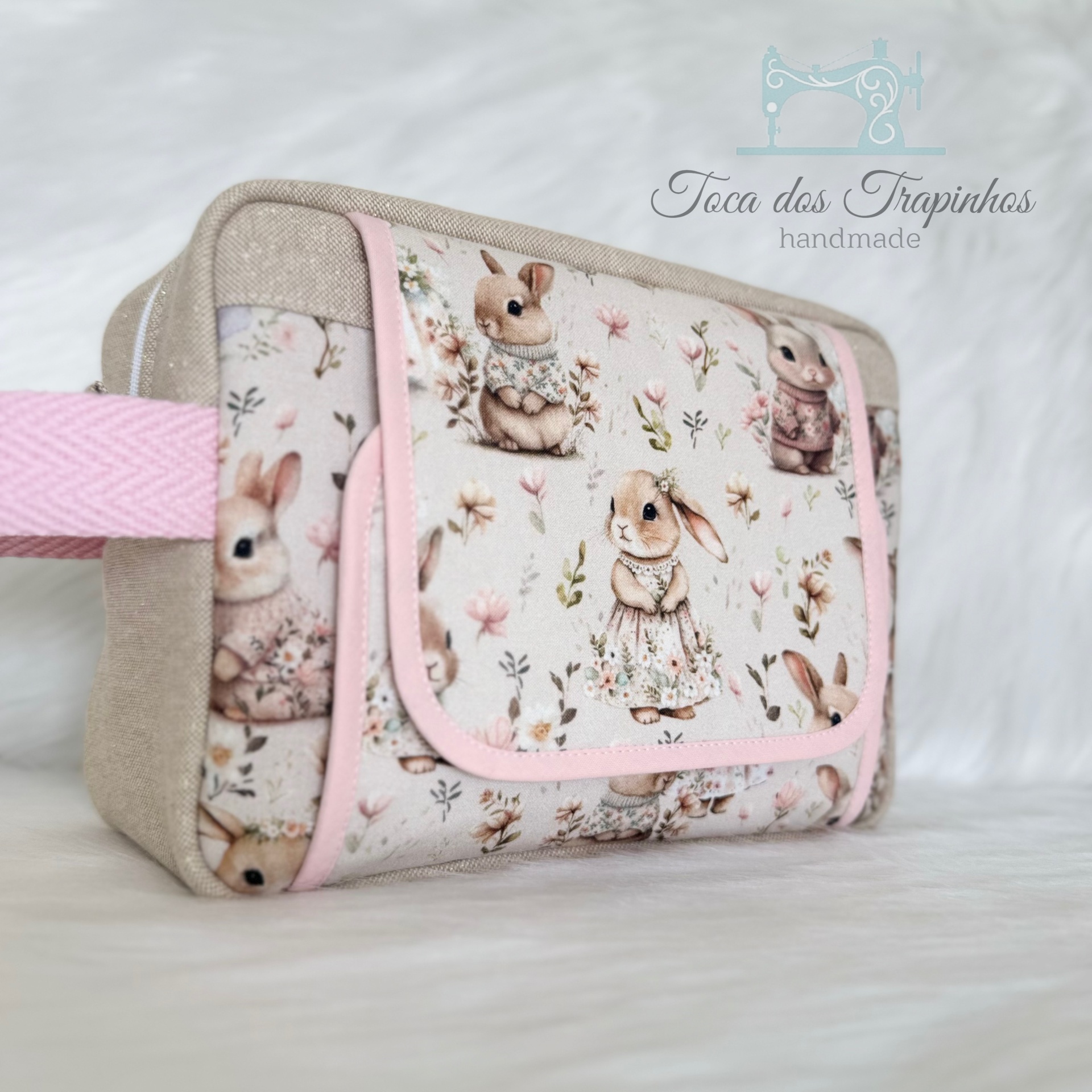 Bolsa pequena retangular com padrão de coelhinhos vestidos e flores, bordas e alça rosa